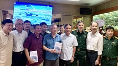 GS Nguyễn Hoàng Nghị (áo xanh, đứng giữa) giới thiệu cuốn sách với các đại biểu tại lễ ra mắt sách. 