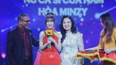 NSND Đức Long và NSND Thái Bảo trao giải thưởng hạng mục "Nữ ca sĩ của năm" cho ca sĩ Hoà Minzy. Ảnh: TTXVN