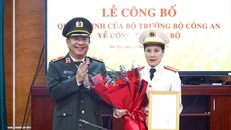 Thiếu tướng Đỗ Triệu Phong trao Quyết định và tặng hoa chúc mừng Đại tá Nguyễn Thị Thu Hằng. Ảnh: CAND