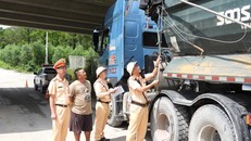 Lực lượng CSGT tiến hành đo chiều cao thành thùng của phương tiện vận tải tại lối ra vào khu vực mỏ đá trong ngày đầu ra quân. (Ảnh: Hoàng Anh)