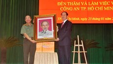 Chủ tịch nước Trần Đại Quang tặng ảnh Bác Hồ cho Công an TPHCM. Ảnh Việt Văn