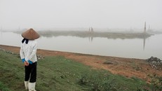 Một phụ nữ đứng trên đoạn đê mới được kè đá do bị sạt lở trên địa bàn xã Quế Tân (Quế Võ, Bắc Ninh). Ảnh: Trường Phong