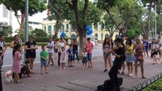 Hình ảnh cậu bé chơi đàn violin trên phố đi bộ quanh Hồ Hoàn Kiếm