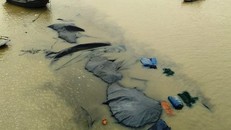 Chiếc sà lan chìm nghỉm chỉ nổi lên các miếng bạt dùng để đậy than. 