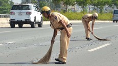 Cảnh sát giao thông quét dọn đá dăm trên đường Phạm Văn Đồng. 