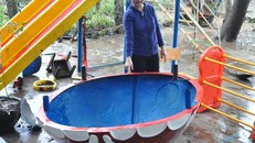 Cô giáo Võ Thị Thu Sương, Hiệu trưởng trường Mầm non An Hiệp bên mô hình mái máng trượt hệt chiếc thúng chai cứu 15 học sinh cùng bốn cô giáo thoát nạn trong lũ quét. 