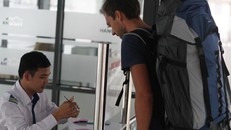 Một vị khách nước ngoài lấy vé buýt nhanh tại bến Kim Mã. 