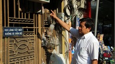 Ông Đoàn Ngọc Hả chỉ đạo dẹp bỏ các biển quảng cáo trên cổng chung cư. Ảnh: Vietnamnet