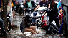 Nhiều người bị đổ xe do triều cường dâng cao. Ảnh: Thanh Niên