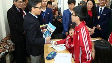 Một em học sinh trường THCS Mạc Đĩnh Chi chia sẻ với Phó Thủ tướng Vũ Đức Đam những loại sách mà em yêu thích. ẢNh: VGP/Đình Nam