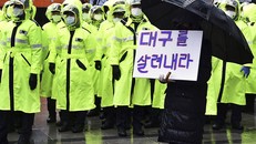 Một người dân Daegu cầm tấm biển với nội dung: "Hãy cứu lấy Daegu". Ảnh: AP