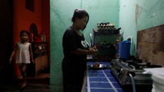 Bà nội trợ Limbu đang nấu ăn trong bếp cùng con gái mình tại phòng trọ ở thủ đô Baniyatar. Ảnh: REUTERS