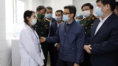 Phó Thủ tướng Vũ Đức Đam động viên một tình nguyện viên tiêm thử nghiệm vaccine phòng COVID-19.