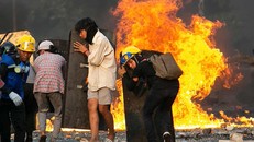 Người biểu tình tại Yangon núp sau các tấm khiên chắn. Ảnh: AFP