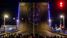 Người dân Saint Petersburg theo dõi buổi chiếu chân dung Yuri Gagarin để đánh dấu kỷ niệm 60 năm chuyến bay vào vũ trụ đầu tiên của con người. Ảnh: Reuters