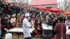 Đám đông tụ tập trước quán mỳ của ông Cheng để xem người này biểu diễn.