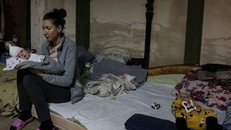 Một bà mẹ bế con ngồi trên nệm trong hầm trú ẩn của Bệnh viện Nhi Okhmadet. Ảnh: Reuters