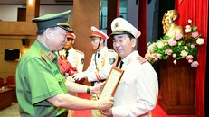 Bộ trưởng Tô Lâm trao Quyết định của Chủ tịch nước thăng cấp bậc hàm từ Thiếu tướng lên Trung tướng đối với đồng chí Trần Quốc Tỏ.