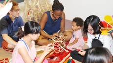 Du khách cùng các em nhỏ thử làm đèn cù tại Trung tâm Di sản Hoàng thành Thăng Long - Hà Nội.