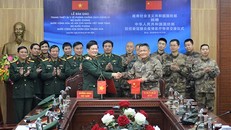 Đại diện Bộ Quốc phòng Việt Nam và Bộ Quốc phòng Trung Quốc trao đổi Biên bản ký kết bàn giao tại Lễ bàn giao trang thiết bị y tế phòng chống, dịch Covid-19 do Bộ Quốc phòng Việt Nam tặng Bộ Quốc phòng Trung Quốc diễn ra ngày 22-2