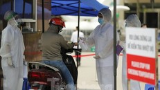 Đo thân nhiệt và yêu cầu dùng dung dịch sát khuẩn trước khi vào bệnh viện Bạch Mai.