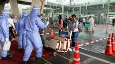 Các nhân viên y tế tiến hành kiểm tra thân nhiệt những người Thái hồi hương từ Abu Dhabi và Ai Cập, hôm 8/5. (Ảnh: Bangkok Post).