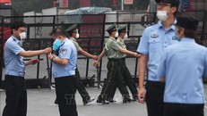 Cảnh sát gác tại lối vào chợ Tân Phát Địa ở Bắc Kinh, Trung Quốc, ngày 13/6, sau khi chợ phải đóng cửa do phát hiện ca nhiễm COVID-19 mới. Ảnh: AFP/TTXVN