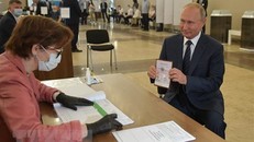 Tổng thống Nga Vladimir Putin (phải) làm thủ tục tại điểm bỏ phiếu trưng cầu dân ý về sửa đổi Hiến pháp ở Moskva ngày 1/7/2020. (Ảnh: AFP/TTXVN)
