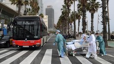 Nhân viên y tế chuyển bệnh nhân COVID-19 về lại bệnh viện sau khi được ra ngoài thư giãn tại Barcelona, Tây Ban Nha ngày 4/3/2021. (Ảnh: AFP/TTXVN)