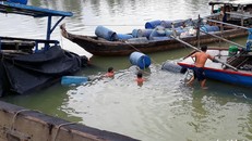 Nhân viên tiến hành trục vớt thuyền chở axit bị chìm - Ảnh: Tuổi trẻ