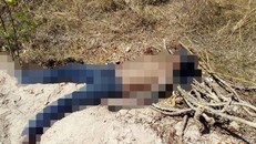 Thi thể nam giới bị bịt mắt, gãy chân trong bãi đất trống. - Ảnh: Tuấn Kiệt.