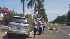 Hình ảnh 3 người đàn ông đứng bấm điện thoại còn nạn nhân nằm giữa đường sau tai nạn. - Ảnh: Zing.vn