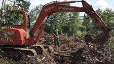 Công an khai quật hố chôn rác thải trong khuôn viên công ty. - Ảnh: Vnexpress