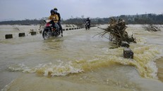 Người dân liều mình đi qua cầu tràn ngập lũ