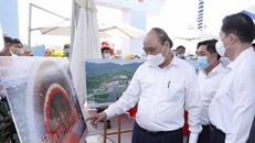 Chủ tịch nước Nguyễn Xuân Phúc xem trưng bày ảnh quá trình thi công Dự án tuyến đường cao tốc Trung Lương-Mỹ Thuận. (Ảnh: TTXVN)