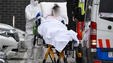 Nhân viên y tế chuyển bệnh nhân COVID-19 lên xe cứu thương tại thành phố Melbourne, Australia. (Ảnh: AFP)