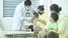 Bác sĩ thăm khám cho bệnh nhi đang điều trị cúm A tại Bệnh viện Bệnh nhiệt đới Trung ương. (Ảnh: TTXVN)