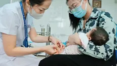 Cần cho trẻ đi tiêm phòng theo đúng độ tuổi. Ảnh: Minh Quyết/TTXVN.