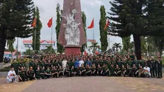 Đoàn cựu chiến binh phía Bắc chụp ảnh kỷ niệm tại Đài tưởng niệm Đăk Tô. Nguồn: Vietnam+