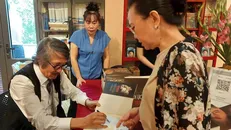 Tiến sỹ Nguyễn Thế Hùng ký tặng sách cho độc giả. Ảnh: Minh Thu/Vietnam+