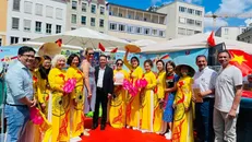Bà Eva Weber (váy xanh nhạt) - Thị trưởng thành phố Augsburg và ông Phạm Huy Phương (áo vest đen) - Trưởng ban Công tác Cộng đồng Đại sứ quán Việt Nam tại Đức chụp ảnh lưu niệm với cộng đồng người Việt tại thành phố Augsburg.