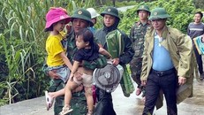 Cán bộ Biên phòng Đồn Ba Nang, tỉnh Quảng Trị, hỗ trợ trẻ nhỏ di dời đến nơi an toàn