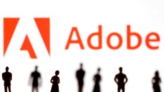 Hình ảnh minh họa những hình nộm nhỏ được đặt phía trước logo Adobe. Ảnh: Reuters/Dado Ruvic
