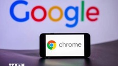 Biểu tượng Chrome trên màn hình điện thoại và biểu tượng Google (phía sau). Ảnh: Getty Images/TTXVN