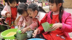 oạt động trải nghiệm gói bánh chưng của học sinh. Ảnh: TTXVN