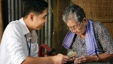 Cán bộ bưu điện chi trả lương hưu, trợ cấp tại nhà cho người già yếu không có khả năng đến nhận. Ảnh: CTV/Vietnam+