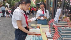 Học sinh tìm hiểu về sách tại Phố sách Hà Nội. Ảnh tư liệu: Đinh Thuận/TTXVN