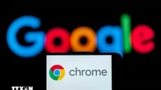 Biểu tượng Chrome trên màn hình điện thoại và biểu tượng Google (phía sau). Ảnh: Getty Images/TTXVN