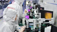 Các kỹ thuật viên làm việc trong xưởng sản xuất chip. Nguồn: Xinhua