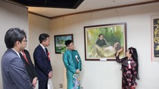 Nữ họa sỹ Văn Dương Thành giới thiệu tranh vẽ về Chủ tịch Hồ Chí Minh. Ảnh: Phạm Tuân